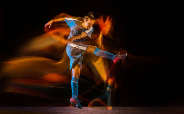 istock Football or soccer player on black background in mixed light, fire shadows 1273297839