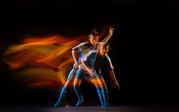 istock Football or soccer player on black background in mixed light, fire shadows 1273297840