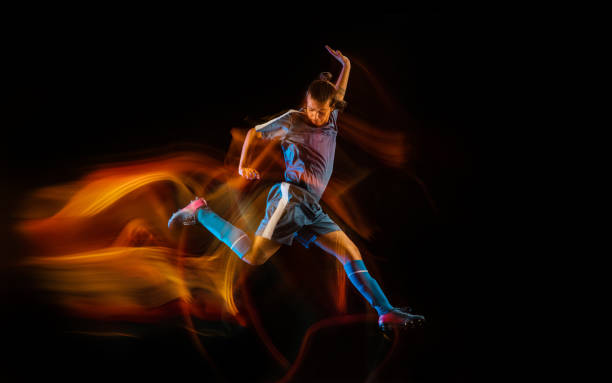 istock Football or soccer player on black background in mixed light, fire shadows 1273297841
