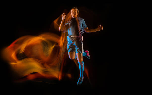 istock Football or soccer player on black background in mixed light, fire shadows 1273297848