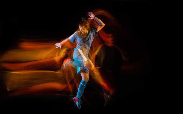 istock Football or soccer player on black background in mixed light, fire shadows 1273297851