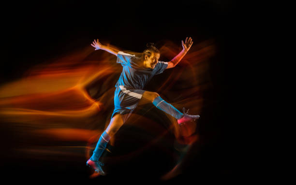 istock Football or soccer player on black background in mixed light, fire shadows 1273297862