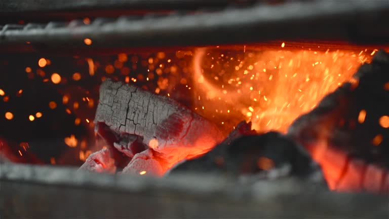 close up of some charcoal burning in a grill in slow motion