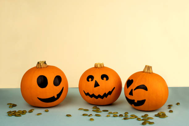 istock Little orange pumpkins with painted faces for Halloween 1273298631