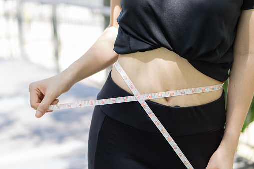 Waist size measurements at outdoor after exercise healthy slim concept