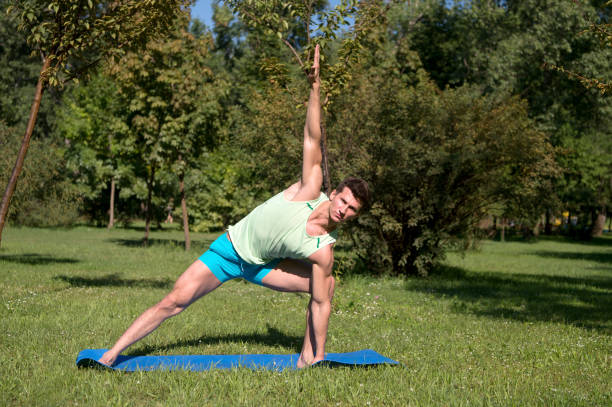istock Athlete stretch hands and legs on blue mat in park 1273300449