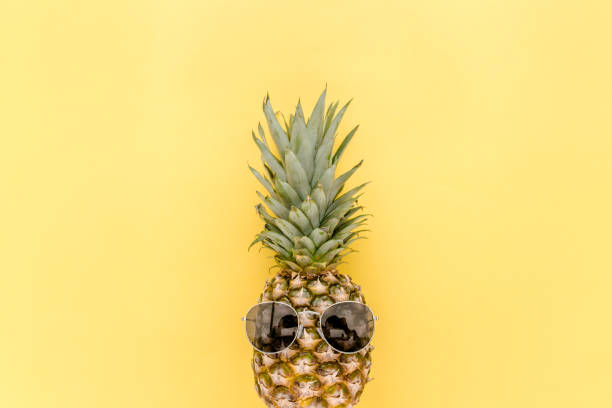 istock Hipster pineapple in sunglasses on yellow background. Summer background. Flat lay 1273302648