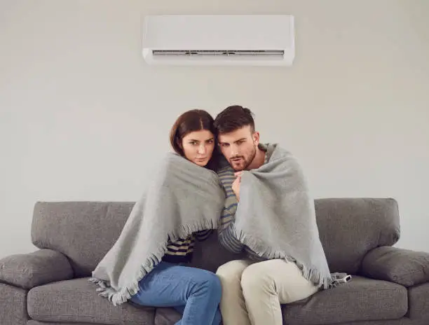 Photo of Freezing couple in cool room cuddling in plaid