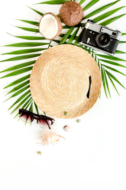 istock Traveler accessories, tropical palm leaf branches, straw hat on white background with empty space for text. Travel vacation concept 1273305439