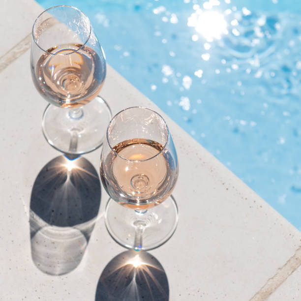 rosé wine by the pool two glasses next to the pool in hard light rose wine photos stock pictures, royalty-free photos & images