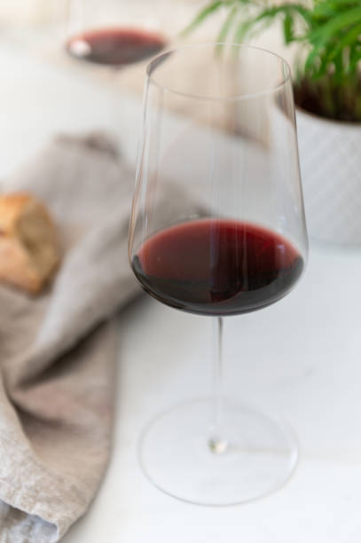 two glasses of red wine and a baguette birds eye view of red wine on a marble countertop wine bar counter stock pictures, royalty-free photos & images