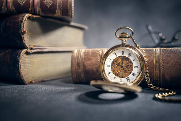 Pocket watch and books in library or study background