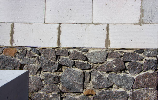 istock Stone foundation and aerated concrete wall, house construction. Building materials for housing. 1273308950