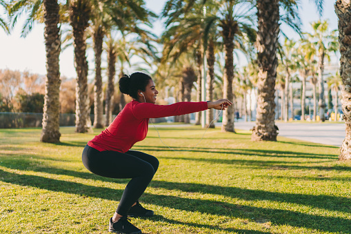 Sportswoman in Barcelona is exercising at city park near the beach