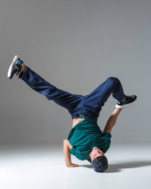 istock Sporty guy breakdancer dancing on the floor isolated on gray background. Breakdance poster 1273314276
