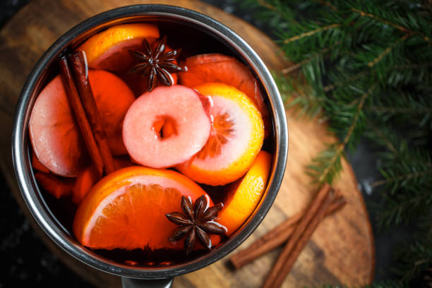 Close-up of apple and orange slices, star anise and cinnamon sticks in mulled wine