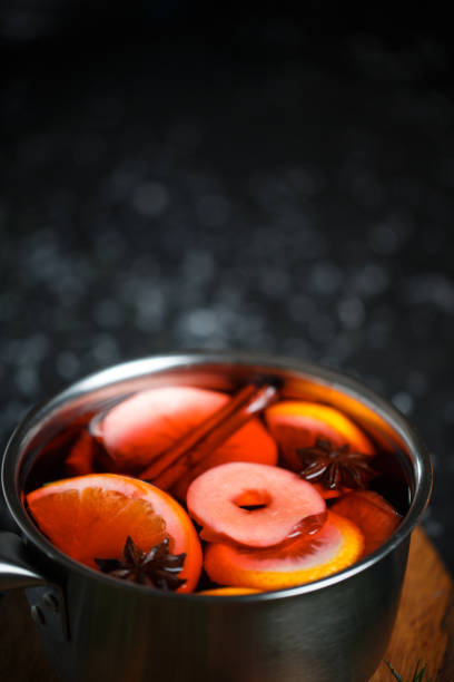 Close-up of apple and orange slices, star anise and cinnamon sticks in mulled wine