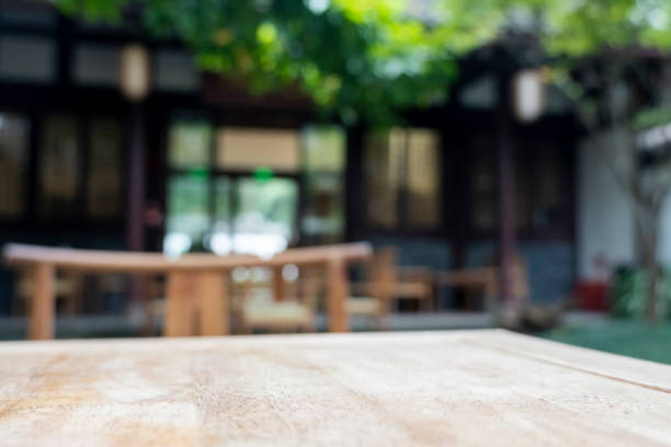 Wooden tables and chairs of an open air Chinese traditional tea house with a lot of trees outdoors In Chengdu. chengdu photos stock pictures, royalty-free photos & images