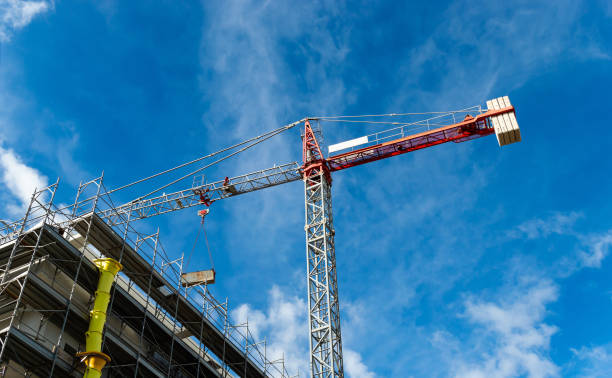 istock Red tower crane building against a blue sky with building 1273317805