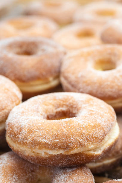 Close-up of freshly baked donuts on the wooden shelf