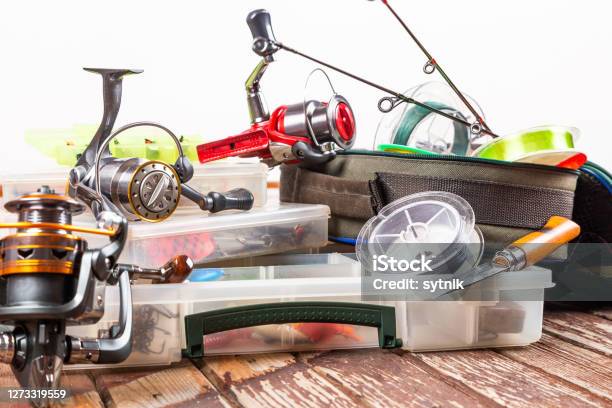Different Fishing Tacles With Rod And Reels On Wooden Brown Background Mockap For Advertisment And Publishing Stock Photo - Download Image Now