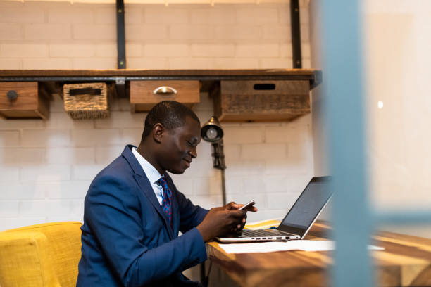 Young business man using mobile phone and laptop