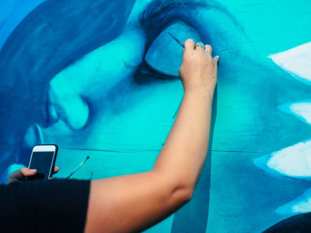 istock Hand of Female mural artist at work 1273321895
