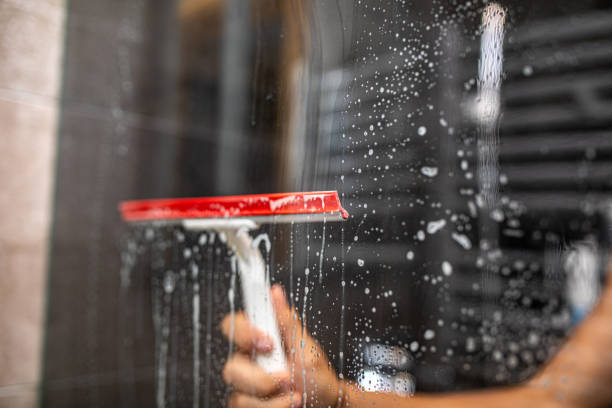Rubber squeegee for cleaning window on the blue background, concept for spring cleaning, copy space