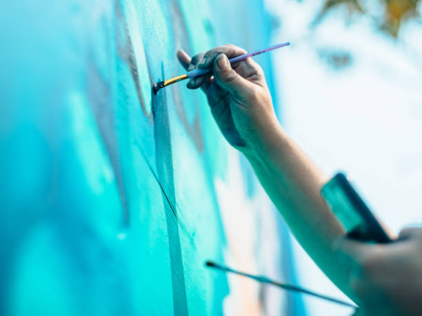 istock Hand of Female mural artist at work 1273322016