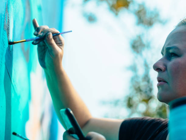 istock Hand of Female mural artist at work 1273322564