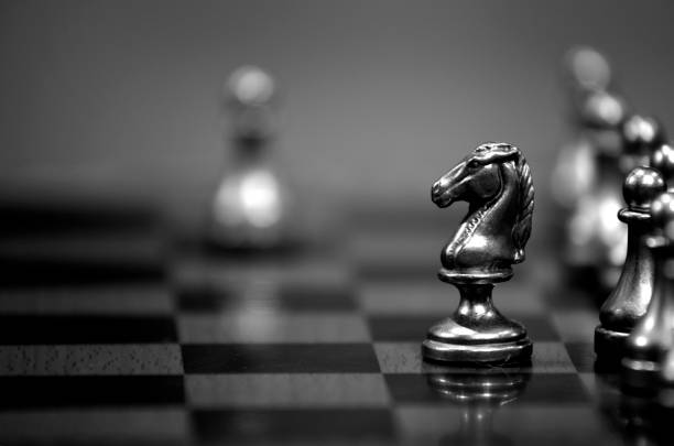 Pieces on chess board for playing game and strategy Pieces on chess board for playing game and strategy knight chess piece stock pictures, royalty-free photos & images