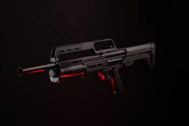 istock Modern tactical pump action shotgun on a dark background. Red backlight. 1273333158