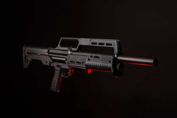 istock Modern tactical pump action shotgun on a dark background. Red backlight. 1273333205