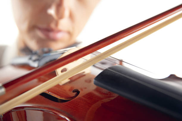 Young girl with long, curly hair with violin in his hand on white background