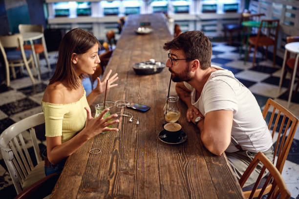 Young couple having drink and discussing in a cafe