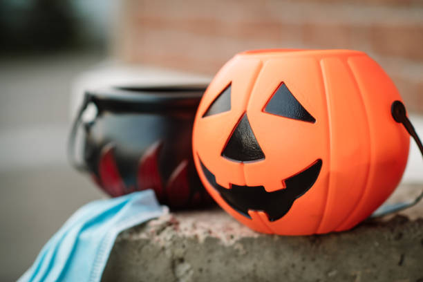 秋のハロウィーンでお菓子と保護フェイスマスクを持つ子供のバスケット - vegies vegetable basket residential structure ストックフォトと画像