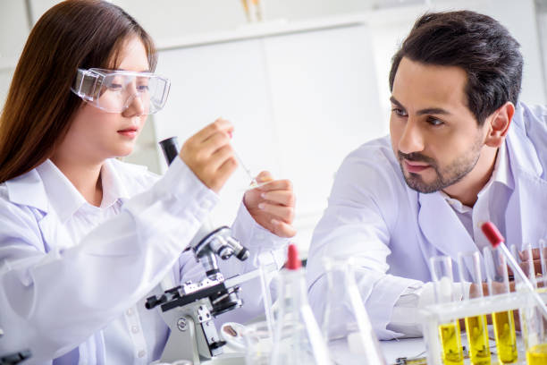 istock Attractive happiness scientist lab technician assistant analyzing sample in test tube at laboratory. Medical, pharmaceutical and scientific research and development concept. 1273335288