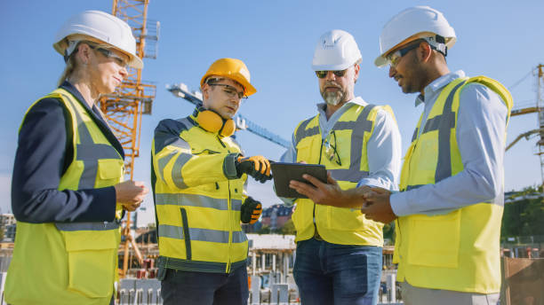 istock Diverse Team of Specialists Use Tablet Computer on Construction Site. Real Estate Building Project with Civil Engineer, Architect, Business Investor and General Worker Discussing Plan Details. 1273337018