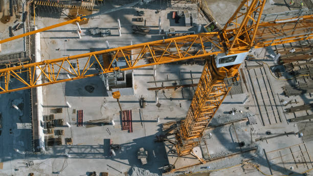 istock Aerial View of a New Constructions Development Site with High Tower Cranes Building Real Estate. Heavy Machinery and Construction Workers are Employed. 1273337093