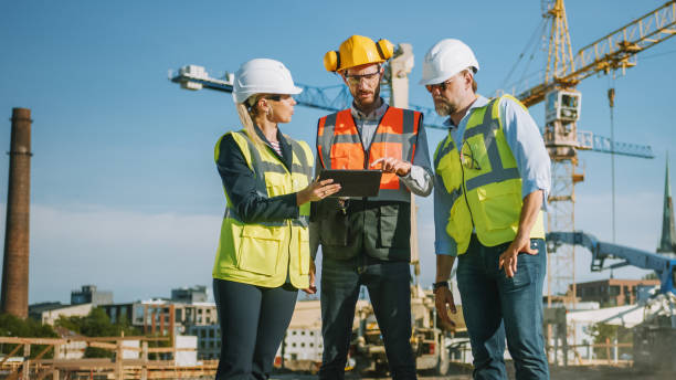 istock Diverse Team of Specialists Use Tablet Computer on Construction Site. Real Estate Building Project with Civil Engineer, Architect, Business Investor Discussing Planning and Development Details. 1273337637