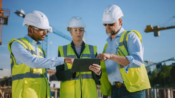 istock Diverse Team of Specialists Use Tablet Computer on Construction Site. Real Estate Building Project with Civil Engineer, Architect, Business Investor Discussing Planning and Development Details. 1273337702