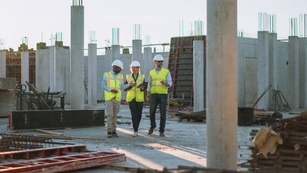 istock Diverse Team of Specialists Taking a Walk Through Construction Site. Real Estate Building Project with Senior Civil Engineer, Architect, General Worker Discussing Planning and Development Details. 1273337757