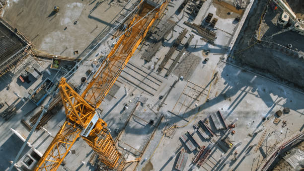 istock Aerial View of a New Constructions Development Site with High Tower Cranes Building Real Estate. Heavy Machinery and Construction Workers are Employed. 1273337760