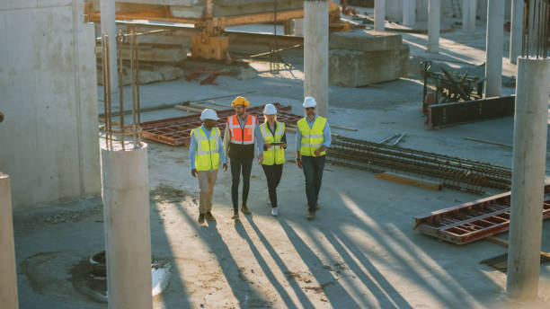 istock Diverse Team of Specialists Taking a Walk Through Construction Site. Real Estate Building Project with Senior Civil Engineer, Architect, General Worker Discussing Planning and Development Details. 1273337767