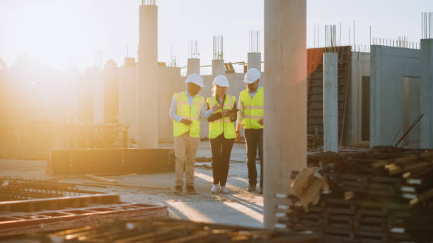 istock Diverse Team of Specialists Taking a Walk Through Construction Site. Real Estate Building Project with Senior Civil Engineer, Architect, General Worker Discussing Planning and Development Details. 1273337776