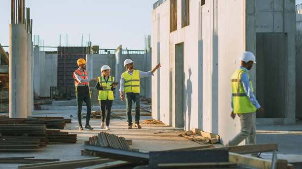 istock Diverse Team of Specialists Taking a Walk Through Construction Site. Real Estate Building Project with Senior Civil Engineer, Architect, General Worker Discussing Planning and Development Details. 1273337786