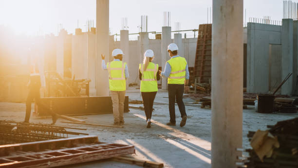istock Diverse Team of Specialists Taking a Walk Through Construction Site. Real Estate Building Project with Senior Civil Engineer, Architect, General Worker Discussing Planning and Development Details. 1273337861