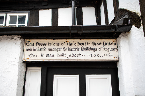 Beaumaris, Wales - September 2nd 2020: Plaque above the entrance to one of the oldest buildings in the UK - built in around 1400, its located in Beaumaris on the Isle of Anglesey in Wales, UK.