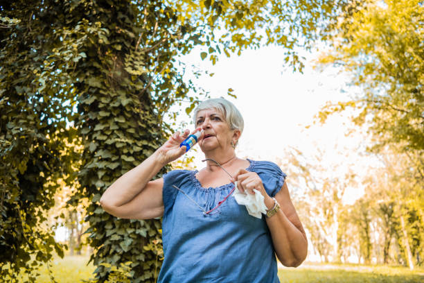 istock Senior woman having flu using nasal spray to help herself. 1273338706
