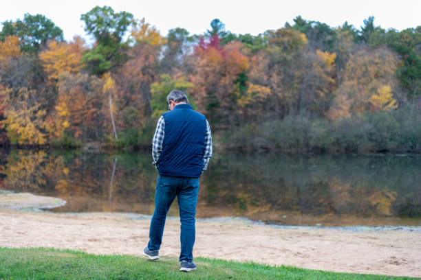 istock Rear View Of Man Walking By Lake 1273338790